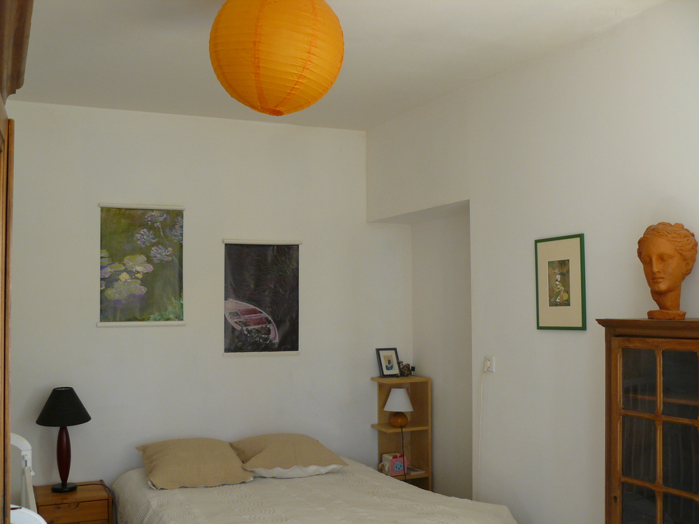 Une chambre avec un lit deux places et un lit de bébé en accès direct sur la terrasse