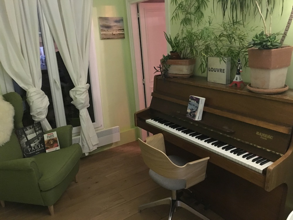 Piano dans le salon, à côté de la fenêtre sur cour